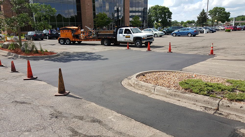 Fresh asphalt paved into the repaired parking lot section
